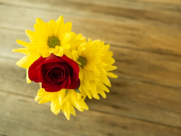 赤はらし、木製のテーブルの背景に黄色の花をぼかし, — ストック写真