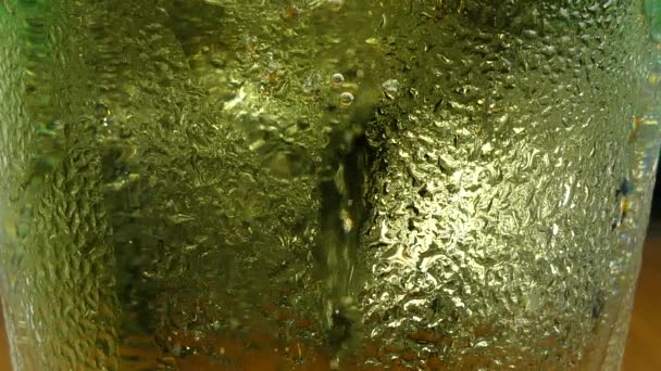 多くは気泡し 発泡と透明ガラス クローズ アップ マクロに黄色の冷たいビールからゆっくりと移動 — ストック動画