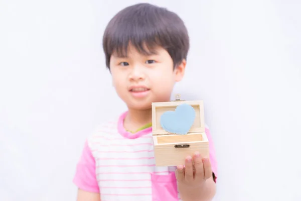 ぼやけた画像かわいい男の子背景にギフト ボックスの青いハート, — ストック写真