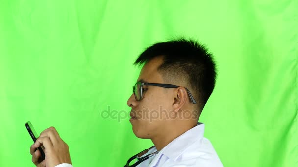 Young Doctor Smartphone Texting Greenscreen Footage Shot Green Screen Keyed — Stock Video