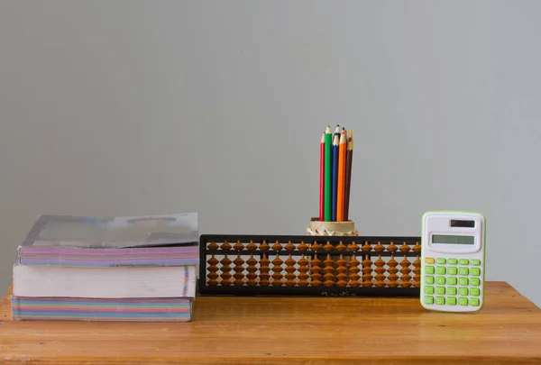 Taschenrechner auf dem Schreibtisch, Farbstift, Bücher auf dem Holztisch, — Stockfoto