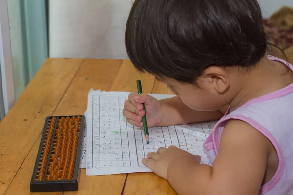Barn skriva numret på papper och träbord. — Stockfoto