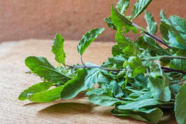 Ahşap bir masa üzerinde taze organik bazilik.