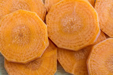 Taze dilimlenmiş havuç ve ahşap arka plan