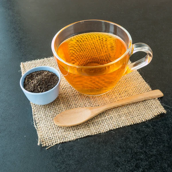 Raw tea in blue cup and Hot tea in glass on black background, — Stock Photo, Image