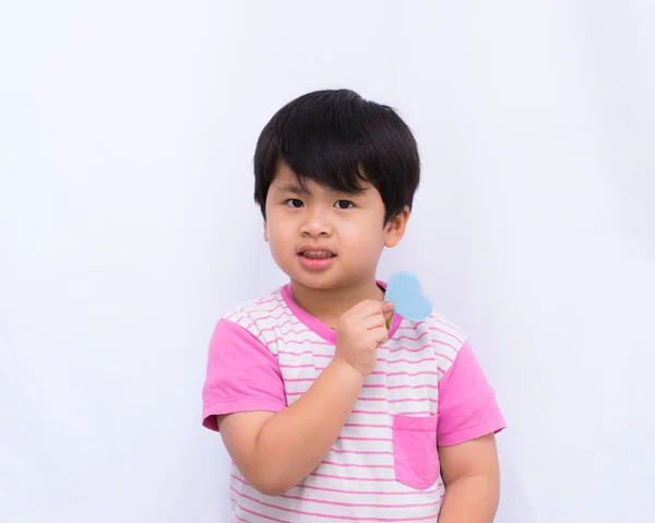 Lindo chico sosteniendo un corazón azul sobre fondo blanco , — Foto de Stock