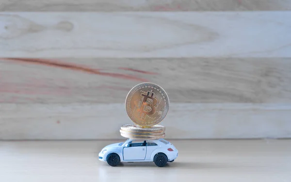 Kryptowährungsmünze in weißem Spielzeugauto auf Holztischhintergrund, — Stockfoto