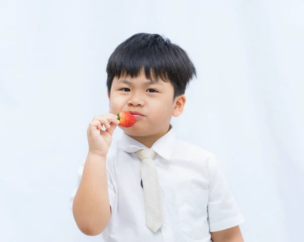 Retrato lindo asiático chico comer rojo fresa en blanco backgroun — Foto de Stock