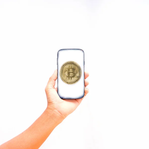 Złota moneta w inteligentny telefon na białym tle, przytrzymanie ręka — Zdjęcie stockowe