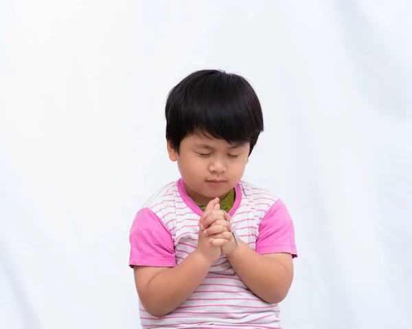 Rozmyte krucyfiksem w dłoni cute chłopiec z zamknąć oczy na whi — Zdjęcie stockowe