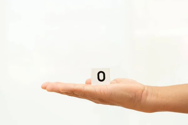 Alphabet number 0 in hand on white background, — стокове фото