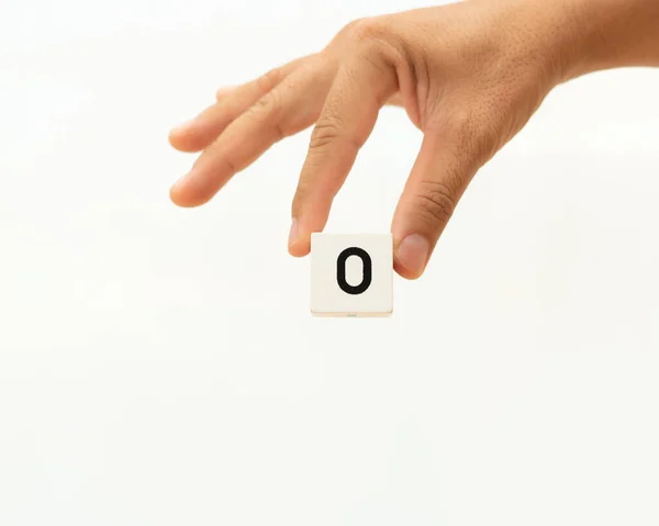 Χέρι κρατώντας τον αριθμό αλφαβήτου 0 σε λευκό φόντο, — Φωτογραφία Αρχείου