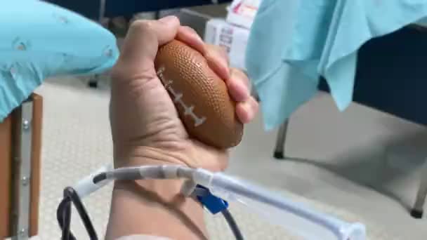 Una Persona Aprieta Una Bola Mientras Dona Sangre Centro Transfusión — Vídeo de stock