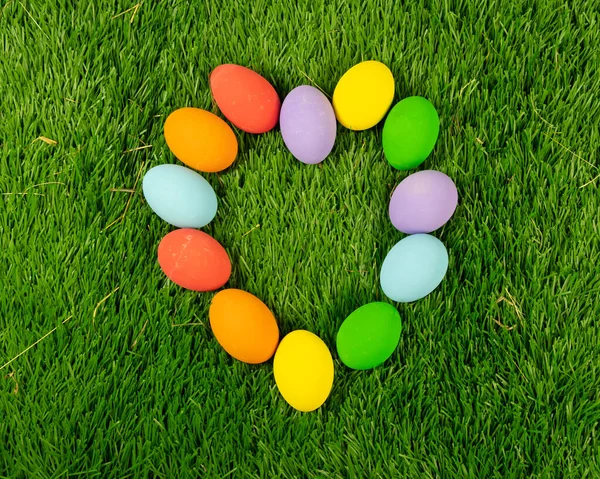 Color Easter eggs in a heart shape. Easter seasonal card concept.