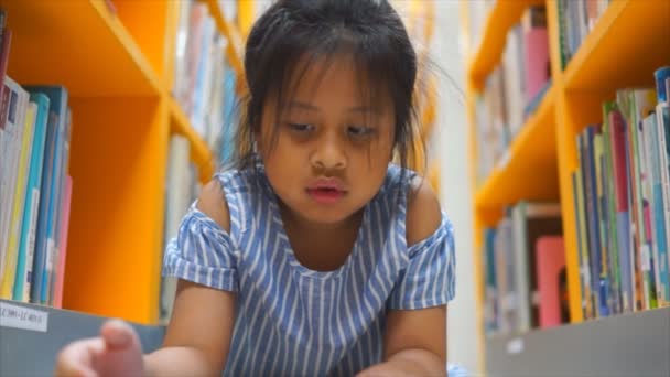 Küçük Bir Kız Kütüphanedeki Okuma Odasında Birçok Kitabın Arasında Ders — Stok video