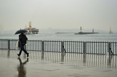 Istanbul Vapur İskelesi insanlar yağmur altında.