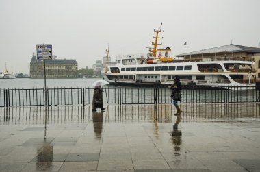 Istanbul Vapur İskelesi insanlar yağmur altında.