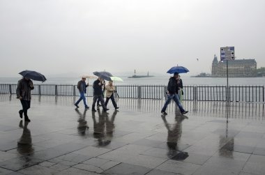 Istanbul Vapur İskelesi insanlar yağmur altında.