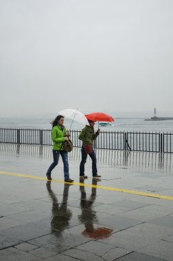 Istanbul Vapur İskelesi insanlar yağmur altında.