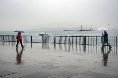 Istanbul Vapur İskelesi insanlar yağmur altında.