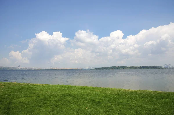 Lago nuvens brancas e campos verdes paisagem Imagens Royalty-Free