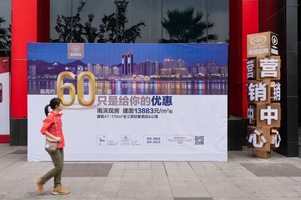 Покупник нерухомості йде по оголошенню про нерухомість у Китаї. — стокове фото