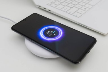 Kablosuz şarj cihazı ile akıllı telefon şarj ediliyor