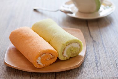 Fincan kahve masada ile renkli rulo pasta