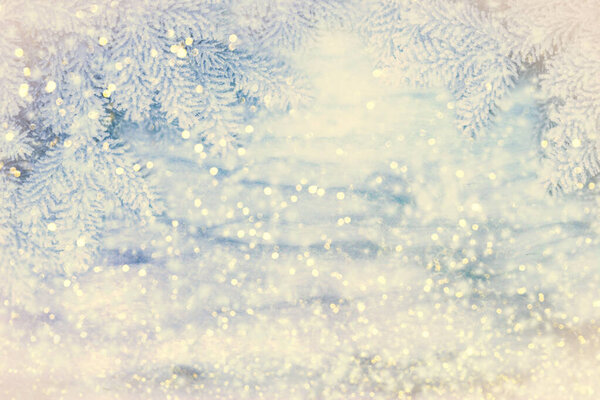 Winter background. Christmas snow landscape with snowdrifts and spruce branches. Falling sparkles and lights bokeh closeup. Mixed media. Soft vintage toned. Greeting card background