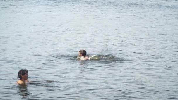 Teenager swims in the lake next to his mother — Stock Video