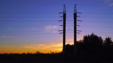 Yüksek gerilim hattı günbatımı bir arka plan üzerinde