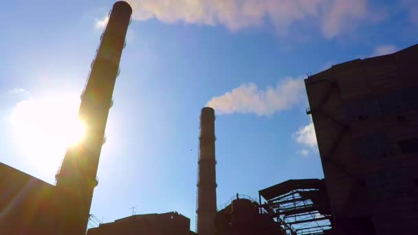 Fumaça da planta metalúrgica tubos. Devido aos tubos pode ser visto o sol — Vídeo de Stock