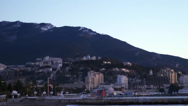 山の背景に海沿いの町。早朝 — ストック動画
