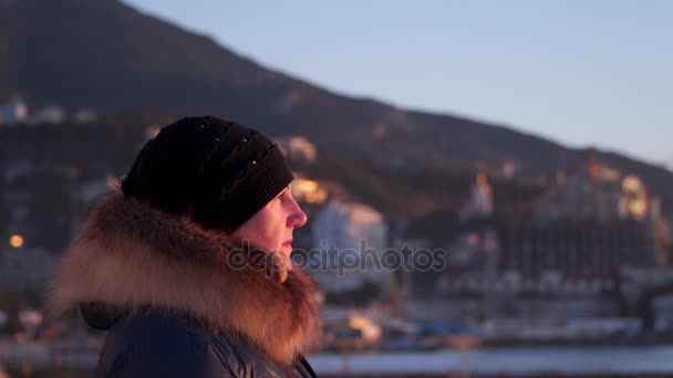 Portret van een vrouw wiens gezicht door de rijzende zon verlicht — Stockvideo