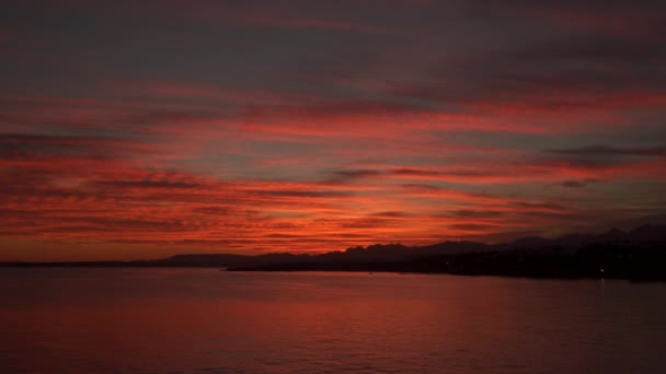 日没で太陽に照らされて、山と海の上の雲 — ストック動画