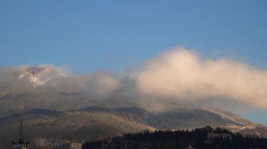 Akşam güneş tarafından aydınlatılmış dağlarda bulutlar