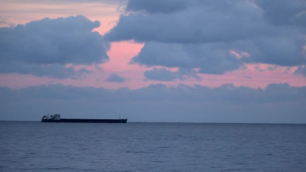 Vrachtschip op de horizon. Avondlucht met wolken — Stockvideo