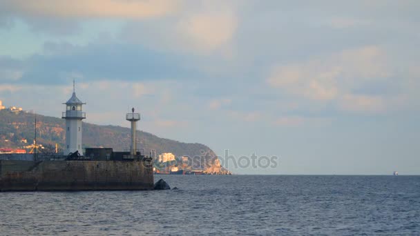 Faro en el muelle en el fondo de las montañas — Vídeo de stock