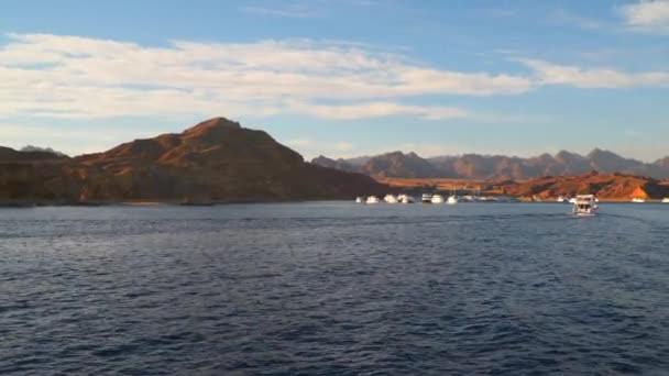 Приборкання човнів у бухті на тлі гір — стокове відео