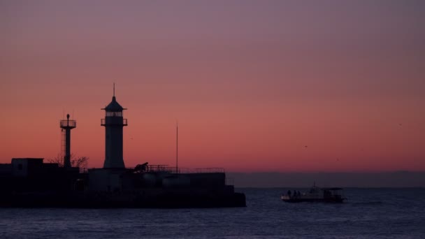 Barcos de pesca al amanecer nadan cerca del faro — Vídeo de stock