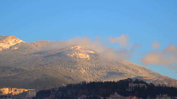 Clouds in the mountains illuminated by the sun at dawn — Stock Video