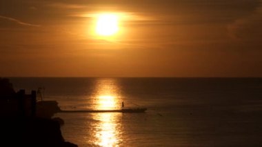 Denizin içinde yükselen güneşin yansıması