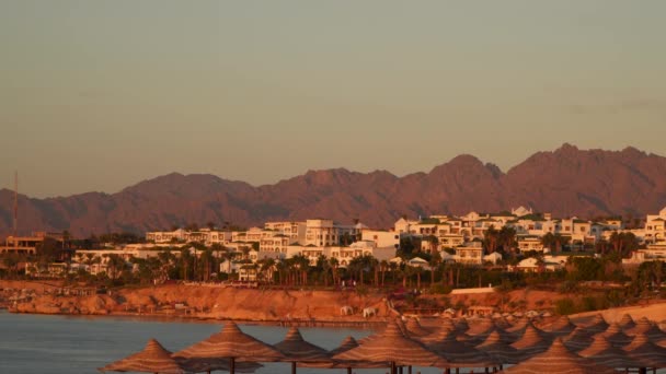 Een resort stadje aan de kust op de achtergrond van de berg — Stockvideo