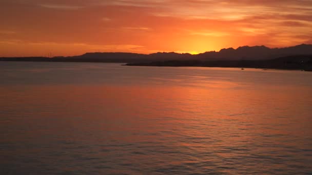 Het licht van de zon bij zonsondergang weerspiegelt in de zee — Stockvideo
