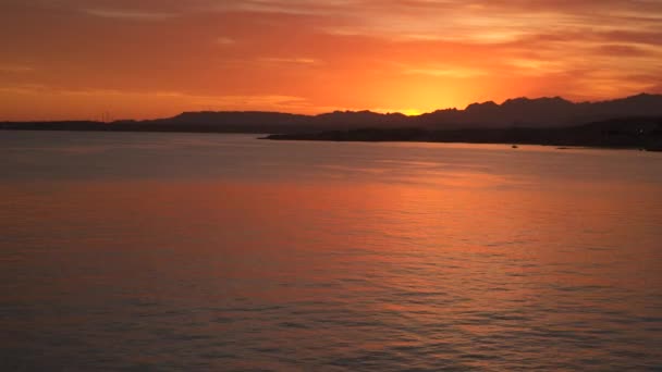 La luz del sol al atardecer se refleja en el mar — Vídeo de stock