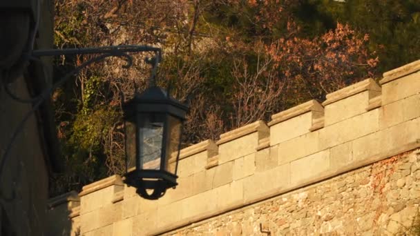 A háttérben a kőfal ősi utcai lámpa — Stock videók