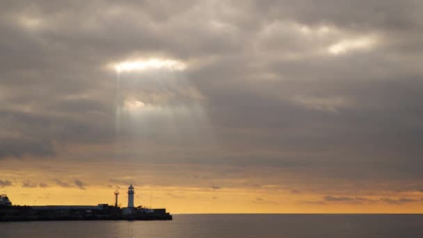 De stralen van de zon verlichten de zee door de wolken — Stockvideo