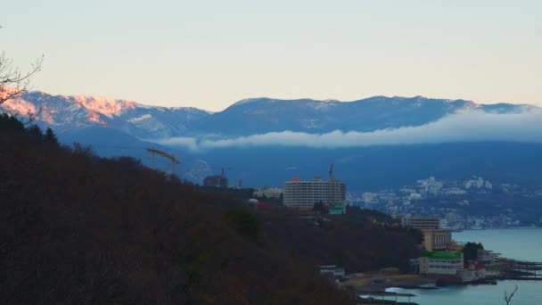 在山脚附近海城市。山云的顶部. — 图库视频影像