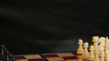 Beyaz ve siyah satranç ile satranç tahtası. Siyah arka plan.