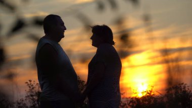 Erkek ve kadın her gün batımı arka plana karşı karşıya